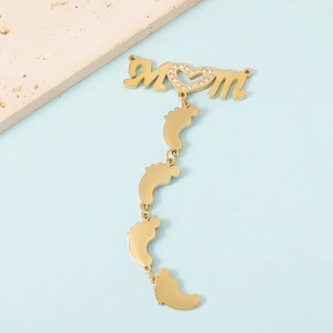 Golden MOM letter pendant with zircon heart and four baby feet charms on blue background