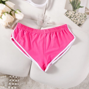 Detailansicht der pinkfarbenen Sportshorts mit weißem Rand und Perlen auf weißem Stoff