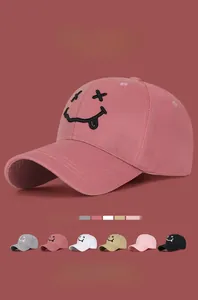 Détail de la broderie visage souriant sur cette casquette de baseball en coton rose chic