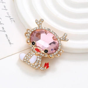 Detailed close-up of a golden dragon brooch featuring a large pink faceted gemstone
