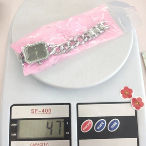 Detailed top view of a luxury rhinestone women's watch on scale showing 47g weight