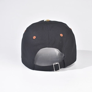 Detail of adjustable metal buckle and contrast orange embroidery on black baseball cap