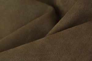 Macro shot of premium dark brown suede fabric texture on a fashion aviator jacket