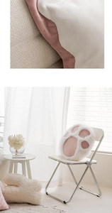 Detail of pink cat paw pillow showing plush texture and a lifestyle scene on a chair