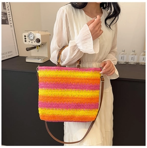 Detail of colorful striped woven beach bag with bamboo handles and brown leather straps