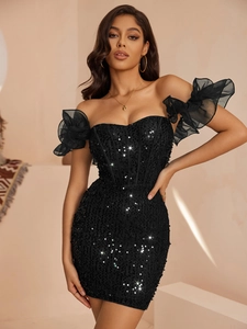 Détail d'une robe noire à paillettes avec d'élégantes manches volantées en tulle