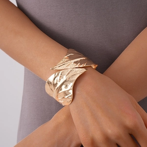 Detail showing the textured leaf vein design of this gold-toned metal open bangle