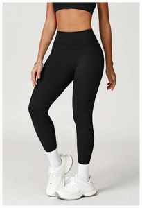 Detail of high waisted black yoga pants showing slim fit silhouette on fitness model