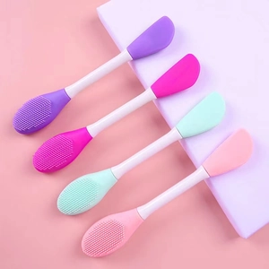 Detail showing four dual-headed silicone face mask brushes in pastel colors and white handles