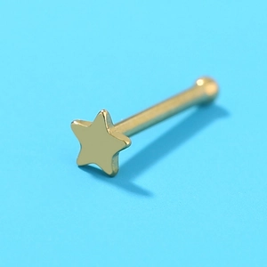 Macro view of gold stainless steel nose stud with star-shaped head on blue background
