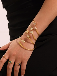Gros plan de pendentifs étoile de mer dorés avec zircons brillants sur des bracelets