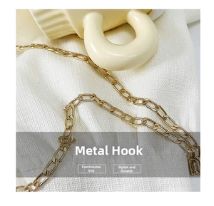 Detailed macro view of a vintage gold-toned rectangular link chain on textured fabric
