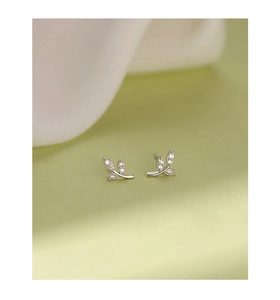 Macro detail of leaf-shaped silver stud earrings with sparkling cubic zirconia stones