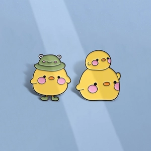 Cute cartoon enamel pins featuring yellow chicks with frog hat and stacked chick design