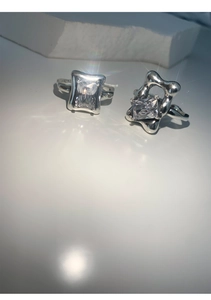Macro shot of 925 sterling silver ring with two sparkling square diamonds on white base
