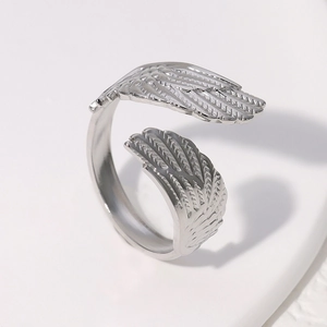 Detailed view of silver wing-shaped stainless steel open ring with bright metallic luster