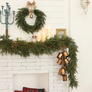 1.8m artificial Norfolk pine garland with rustic burlap bow and copper bells on fireplace