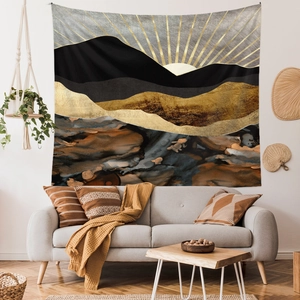 Close-up of abstract mountain wall tapestry with golden sun rays in a modern living room