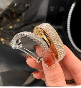 Macro view of gold and silver curved hair clips with shimmering rows of rhinestones
