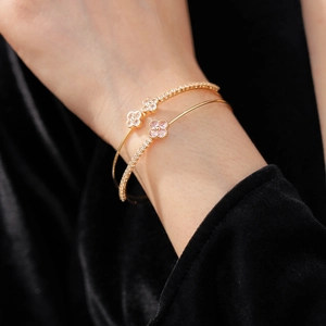 Detail of double-layer clover bracelet with pink and white zircon on model's wrist