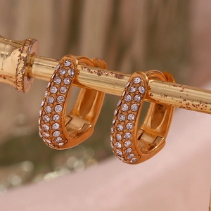 Macro shot of gold-plated hoop earrings with micro-paved white zirconia stones