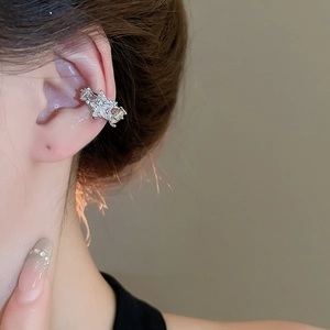 Close-up of a silver star-shaped ear cuff featuring sparkling white zircon stones