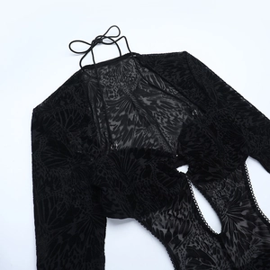 Close-up of black mesh jumpsuit featuring intricate flocked butterfly patterns and lace ties