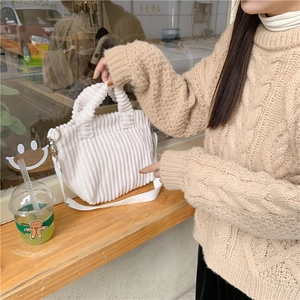 Détail d'un sac bandoulière en velours côtelé blanc avec bandoulière réglable en toile