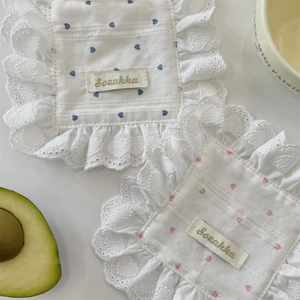 Lace-edged table placemats with blue and pink heart patterns in a cozy setting