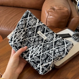 Detail of bohemian floral embroidery on a black canvas pouch with Simple Wish label