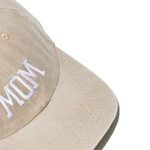 Close-up of white MOM letter embroidery on khaki cotton fabric of a baseball cap