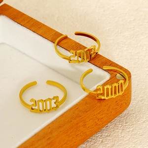 Gold plated stainless steel year rings in gothic font with adjustable open band