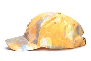 Detail of yellow and purple floral baseball cap with metal buckle and side ornament