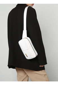 Close-up of white quilted PU leather chest bag with golden zipper and wide strap