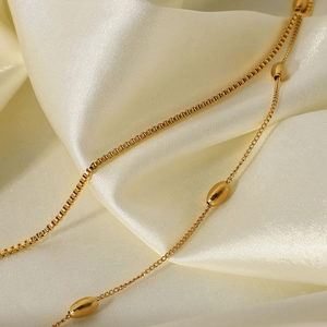 Elegant 18K gold plated stainless steel layered necklace with oval beads on white silk