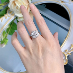 Detailed view of an S925 silver camellia flower ring with small diamond settings on a finger