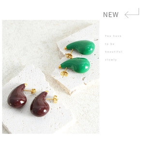 Detail of water-drop enamel studs in green and brown on stone props with golden pins