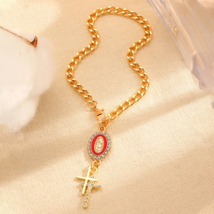 Détail d'un bracelet gourmette doré avec médaille de la Vierge Marie rouge et croix