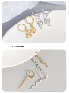 Detail of gold and silver S925 sterling silver hoop earrings with dangling snake charms