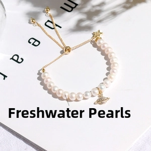 Detailed close-up of 14K gold plated bracelet featuring baroque pearls and celestial charms