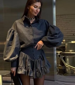 Detail of dark gray shirt with puff sleeves and ruffled mini skirt set texture
