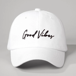 Classic white cotton baseball cap with black Good Vibes embroidery on a light background