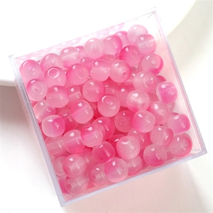 Top view of pink gradient cat-eye glass beads in a clear box for DIY jewelry making
