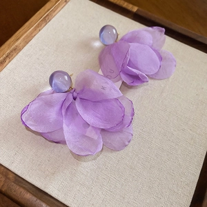 Macro view of purple petal earrings with chiffon fabric layers and resin stud detail