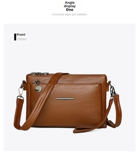 Front view of a brown multi-layer crossbody bag with textured leather and metal zippers