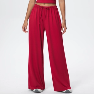 Detail of red high-waisted wide-leg athletic pants featuring adjustable drawstring waist