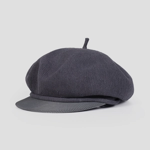 Gros plan d'une casquette gavroche grise tricotée montrant la texture et le bord court