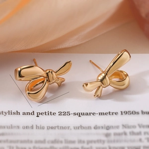 Détail de boucles d'oreilles nœud doré avec dimensions 1,7x2,4cm et poids 8g indiqués