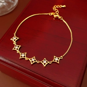 Détail d'un bracelet étoile plaqué or 18k avec zircon sur un coffret en bois de luxe