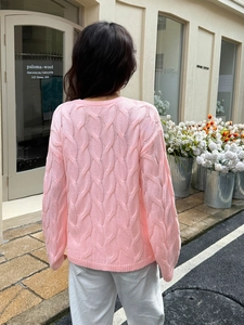 Women's pink cable knit sweater featuring a long sleeve pullover design and back details